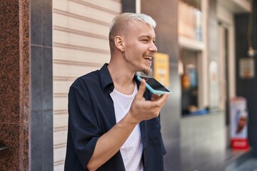 Obraz na płótnie Canvas Young caucasian man smiling confident talking on smartphone at street
