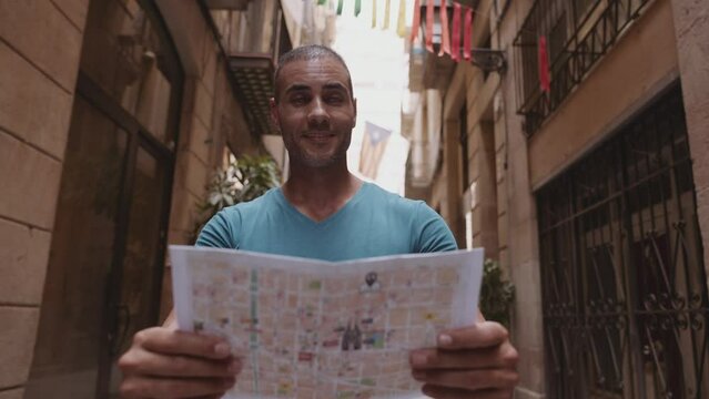 Happy male tourist maps user walking in old town alley an using a map. Barcelona, Spain. Cinematic 4K