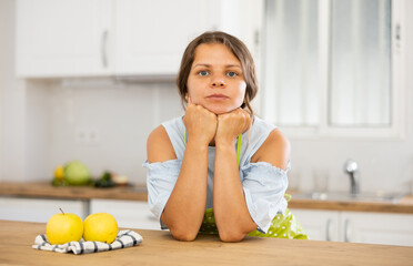 Obraz na płótnie Canvas Young attractive landlady posing in a modern kitchen