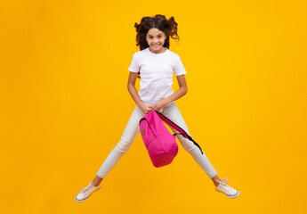 School girl in school uniform with school bag. Crazy run and jump. Schoolchild teenager hold backpack on yellow isolated background.