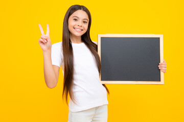 Teenage girl child hold chalkboard. Elementary school girl holding a blank blackboard chalk board. Copy space, mockup banner. Happy teenager portrait. Smiling girl.