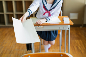 教室 プリントを渡す女子高生