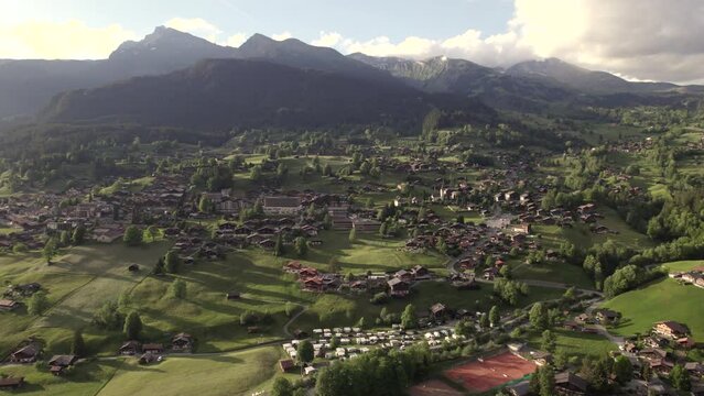 aerial drone footage dolly left to right of beautiful sunset view of grindelwald village in the swiss alps