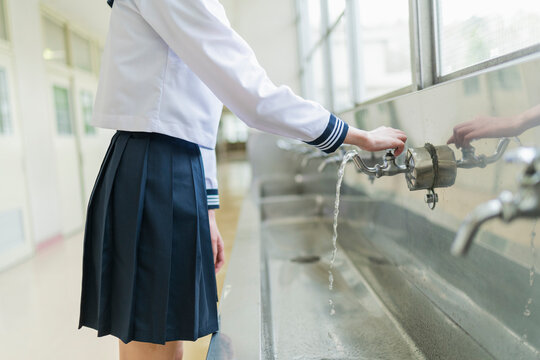 学校 廊下 水を飲む女子高生