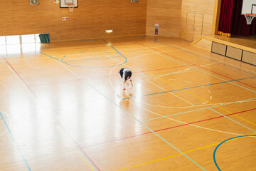 Fototapeta na wymiar 体育館でボール遊びをする女子高生