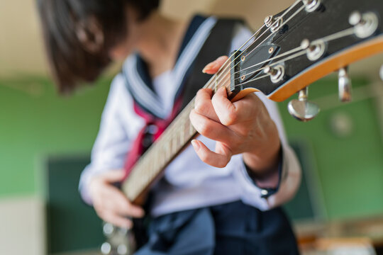 教室でギターを弾く女子高生