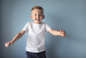 Happy smiling little boy jumping in studio setting. 