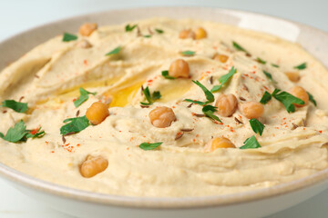 Tasty hummus with garnish in bowl, closeup