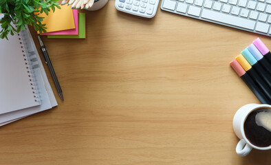Flat lay calculator, sticky notes, notebook and coffee cup on wooden table. Top view with copy space.