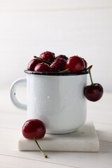 Fresh ripe cherries with water drops on white wooden table
