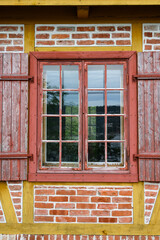 Traditional European architecture of red brick and wood, red windows and shutters
