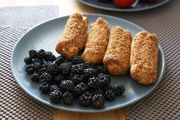 eclairs and blackberries on a blue plate