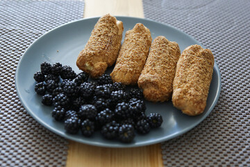 eclairs and blackberries on a blue plate