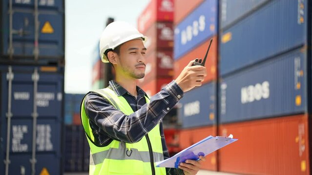 Asian handsome man engineer worker working in container port terminal. 