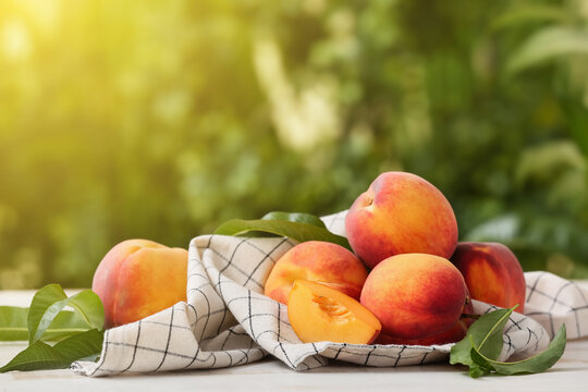 Sweet ripe peaches on table outdoors