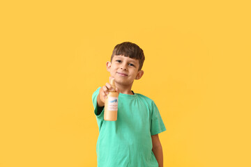 Little boy with mosquito repellent on color background