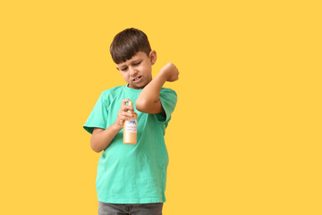 Little boy with mosquito repellent on color background