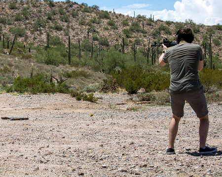 Person Shooting Gun While Wearing Ear Protection On Hot Sunny Arizona Summer Day