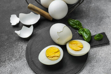 Board with boiled chicken eggs on black and white background, closeup