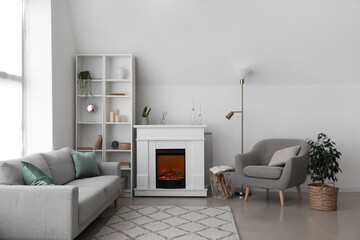 Interior of light living room with fireplace, shelving unit and armchair