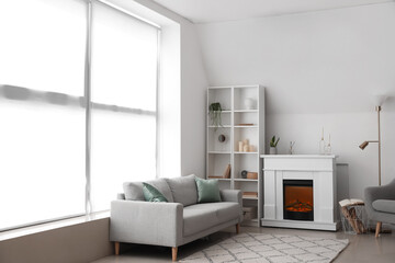 Interior of light living room with fireplace, shelving unit and sofa