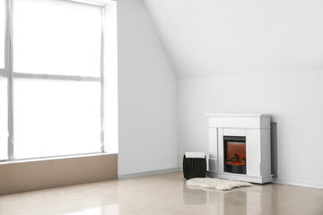 Obraz na płótnie Canvas Pouf with magazine and modern fireplace near light wall