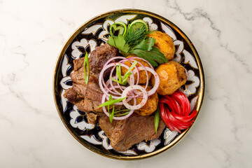 Kazan kebab with beef on plate top view on marble table