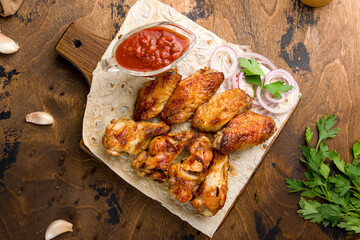skewers of chicken wings with tomato sauce and red onion on the board top view