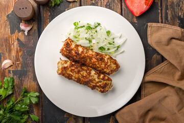 Lula kebab chicken on white plate on wooden table top view