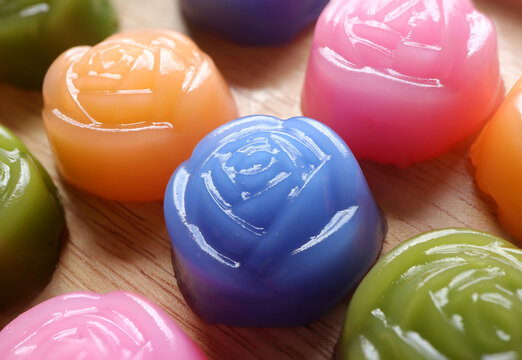 Kanom Chan or Steamed Layer cake. Thai traditional dessert. Layer sweet cake made in the shape of rose on wooden background.Top view