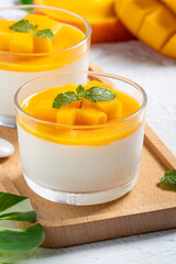 Delicious double colored mango panna cotta mousse pudding on white table background.