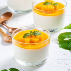Delicious double colored mango panna cotta mousse pudding on white table background. - obrazy, fototapety, plakaty