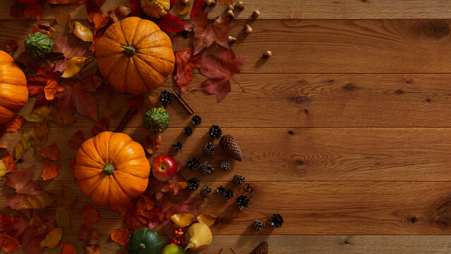 Thanksgiving Background with Autumn leaves, Pumpkins and Acorns on a Natural wood Tabletop.