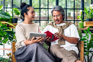 Senior couple asian family having good time using tablet computer together.Happy elderly husband and wife checking social media and reading news or shopping online while sitting at home.