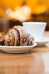 Delish chocolate croissant like rugelach and a cup of coffee in a restaurant.