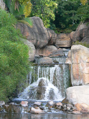 Waterfall in a garden surrounded by stones and plants