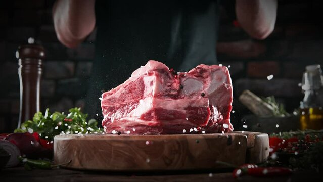 Super slow motion of falling spices on beef steak. Filmed on high speed cinema camera, 1000 fps.  Meat preparation in kitchen. Speed ramp effect.