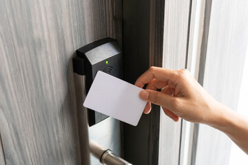 Woman hand using electronic smart key card to unlock door in hotel or house. Digital lock, door access control, contactless concept. Closeup, copy space - Powered by Adobe
