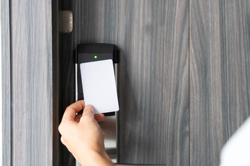 Woman hand using electronic smart key card to unlock door in hotel or house. Digital lock, door access control, contactless concept. Closeup, copy space