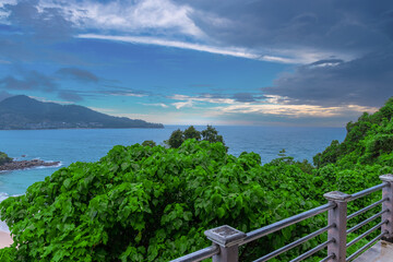 Obraz premium Colourful Skies Sunset over Head Laem Sing Beach in Phuket Thailand. This Lovely island waters are turquoise blue waters, lush green mountains colourful skies and beautiful views of Pa Tong Patong