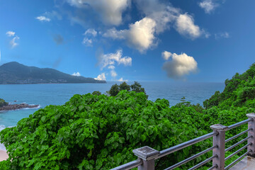 Fototapeta premium Colourful Skies Sunset over Head Laem Sing Beach in Phuket Thailand. This Lovely island waters are turquoise blue waters, lush green mountains colourful skies and beautiful views of Pa Tong Patong