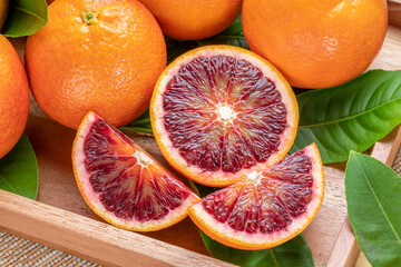 Blood orange fruit in wooden basket on wooden background, Red Blood orange with slice in wooden...