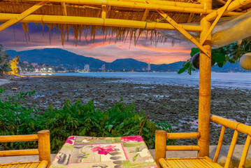Colourful Skies Sunset over Kalim Beach Patong Pa Tong Beach in Phuket island Thailand. Lovely turquoise blue waters, lush green mountains colourful skies