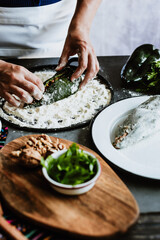 cooking mexican battered chiles en nogada recipe by woman hands with Poblano chili and ingredients, traditional dish in Puebla Mexico	