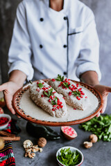 mexican woman chef cooking chiles en nogada recipe with Poblano chili and ingredients, traditional dish in Puebla Mexico	