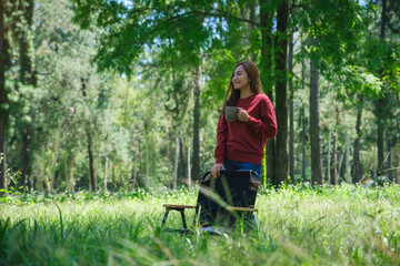 Portrait image of a beautiful young asian woman drinking coffee in the park