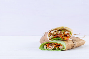 Delicious shawarma sandwich with chicken on wooden background