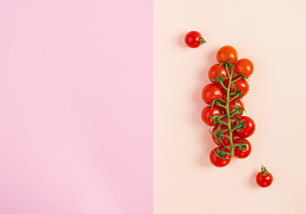 Isolated fresh red cherry tomatoes on pink-beige background. Top view. Flat lay