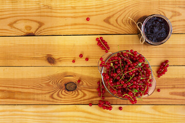 Jar with jam of red currant on a wooden background. Top view