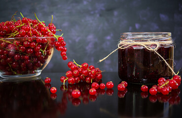 Jar with jam of red currant on dark background